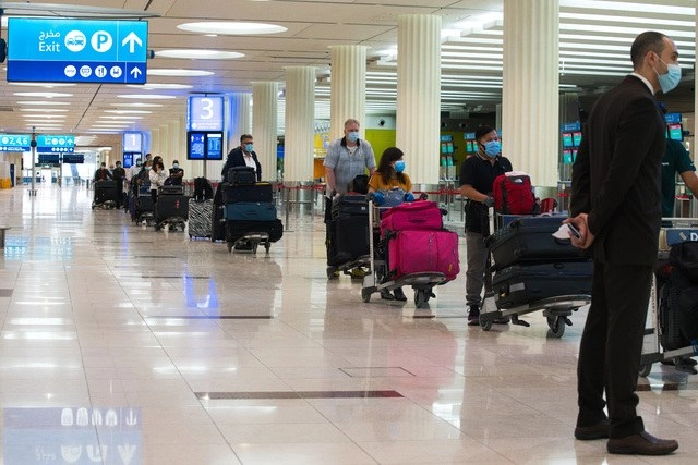 Volar en avión se ha convertido en una experiencia compleja por la pandemia, ya que hay que llevar mascarilla, certificados médicos y pasar varias horas de controles. La imagen, en el aeropuerto internacional de Dubai. Foto Ap