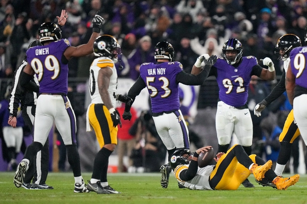 El quarterback de los Pittsburgh Steelers, Russell Wilson, tras ser capturado por el tackle defensivo de los Baltimore Ravens, Nnamdi Madubuike (92), celebrando con el linebacker Kyle Van Noy (53) y el linebacker Odafe Oweh (99), durante la segunda mitad de un partido de comodines de la NFL. Foto Ap