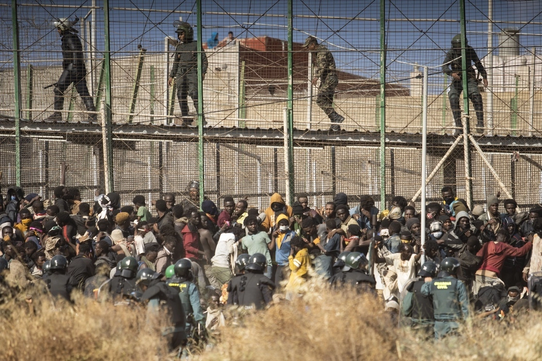 El 24 de junio pasado, oficiales antidisturbios cercan el área tras la llegada de migrantes a territorio español, en la reja que separa el enclave de Melilla de Marruecos. Foto Ap
