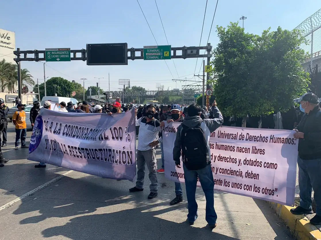 Un grupo de ex policías federales durante su bloqueo sobre Circuito Interior, frente al Aeropuerto Internacional de la Ciudad de México, en exigencia de que se les condonen adeudos de vivienda, el 28 de mayo de 2021. Foto Alfredo Domínguez