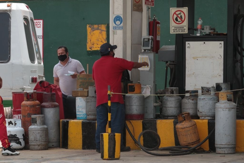 Trabajadores de gaseras de la alcaldía Iztapalapa comienzan a abastecer a usuarios que llevan tanques de gas, en la Ciudad de México. Foto Alfredo Domínguez



