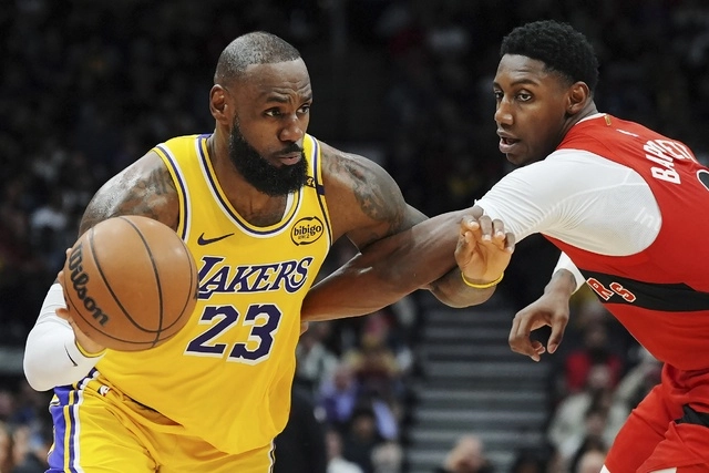 LeBron James (23) de Los Angeles Lakers conduce mientras RJ Barrett (9) de los Toronto Raptors defiende durante la segunda mitad del juego. Foto Ap