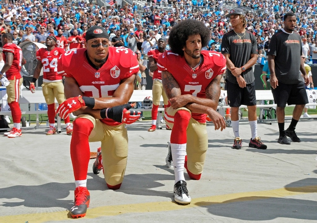 Eric Reid (35) y Colin Kaepernick (7), de los 49ers de San Francisco, se arrodillan durante el Himno de Estados Unidos antes del partido ante las Panteras de Carolina el 18 de septiembre de 2016. Foto Ap