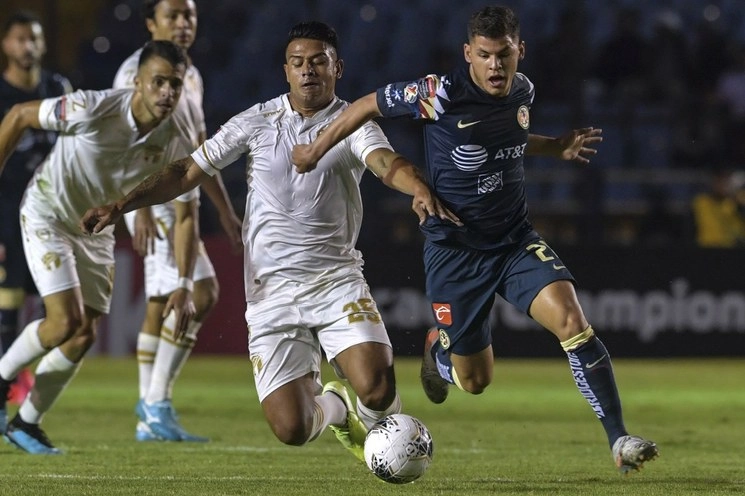 Alejandro Galindo de Comunicaciones (izq) disputa la esférica con el jugador de América, Richard Sanchez (der). Foto Afp