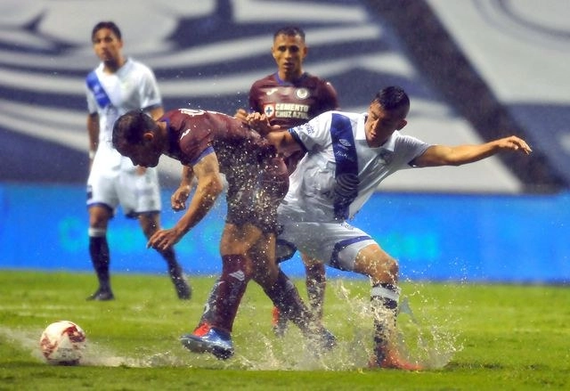 Daniel Álvarez (der) del Puebla disputa la esférica con Adrián Aldrete (izq) del Cruz Azul. Foto Afp