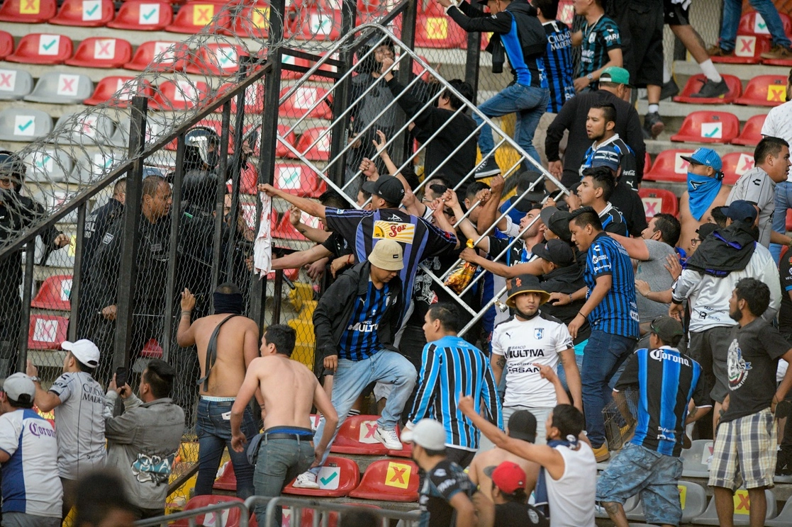 Enfrentamiento entre aficionados de Atlas y Querétaro en el estadio Corregidora. Foto Ap