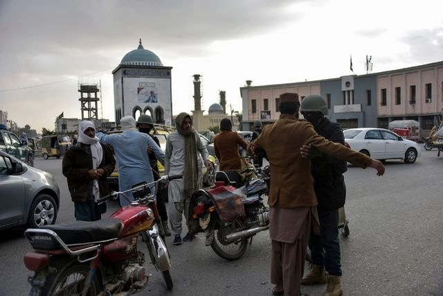 Policías afganos revisan a un grupo de personas en Kandahar, tras los ataques talibanes. Foto Afp 