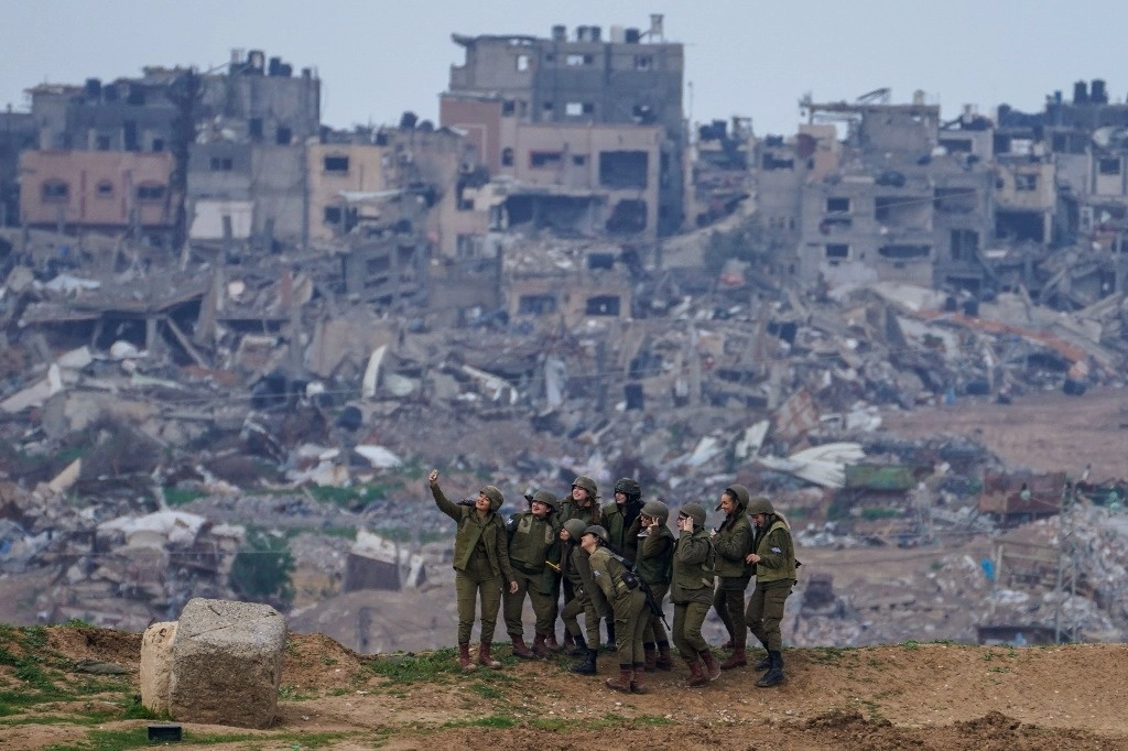Mujeres militares israelíes se toman una selfi con las ruinas de la franja de Gaza a sus espaldas. Las fuerzas armadas de Tel Aviv informaron que ayer atacaron Jan Yunis, donde han enfocado su guerra en las semanas recientes. Funcionarios de Salud palestinos señalaron que más de 29 mil personas han perecido por los bombardeos aéreos del gobierno de Netanyahu. Foto Ap