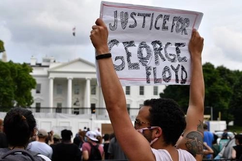 Un manifestante sostienen un cartel frente a la Casa Blanca.Foto Afp