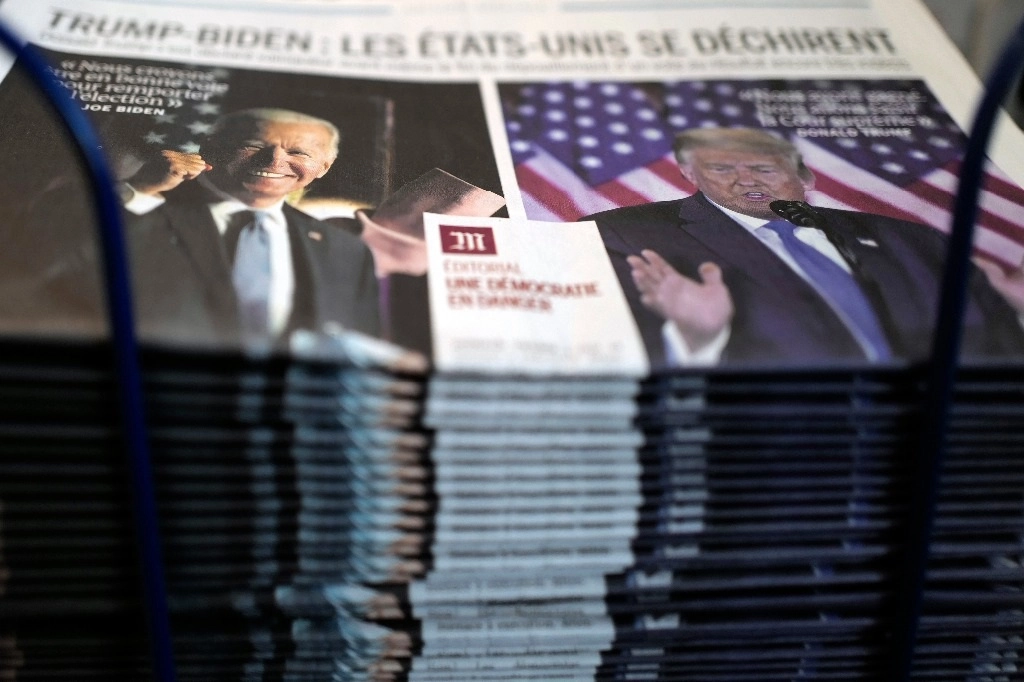 Una pila de ejemplares del periódico francés 'Le Monde' titula "Trump-Biden: Estados Unidos se está destrozando, Editorial: una democracia en peligro" sobre las elecciones presidenciales de EU, en un puesto de periódicos en París. Foto AP