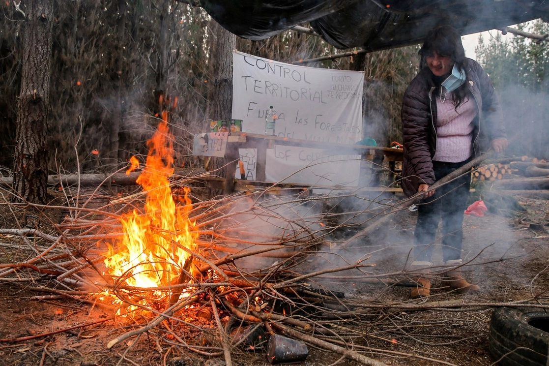 Un militante del grupo mapuche Coordinadora Arauco Malleco enciende una fogata durante la ocupación de las tierras de una empresa forestal en Traiguen, región de la Araucanía. Foto Afp / Archivo