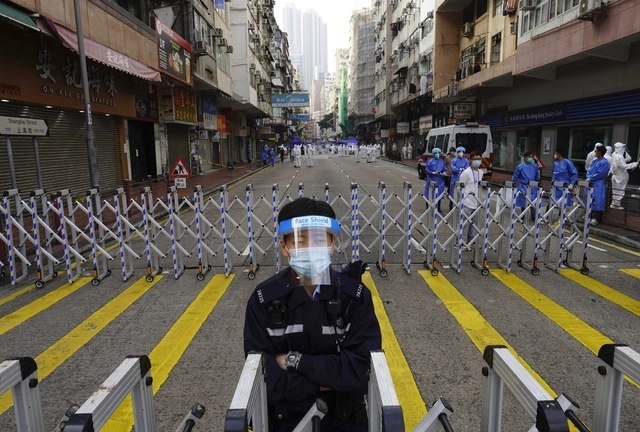 Autoridades resguardan la zona bajo confinamiento de Hong Kong donde residen cerca de nueve mol personas. Foto Ap  