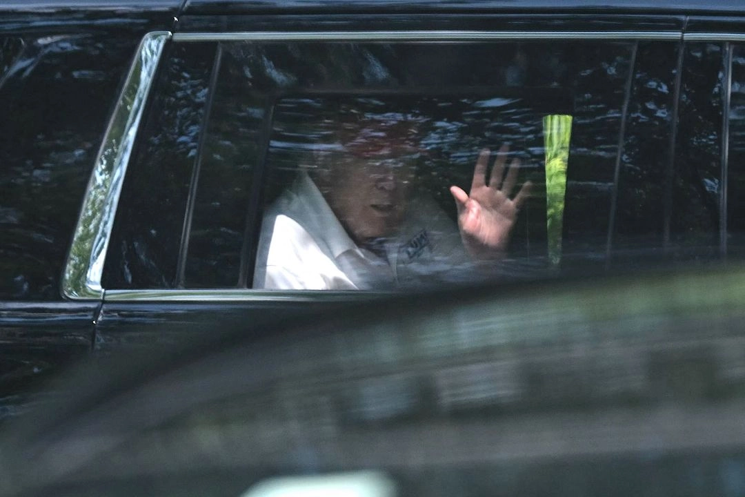 El presidente de Estados Unidos, Donald Trump, saluda desde su automóvil al salir de su club de golf en Sterling, Virginia.