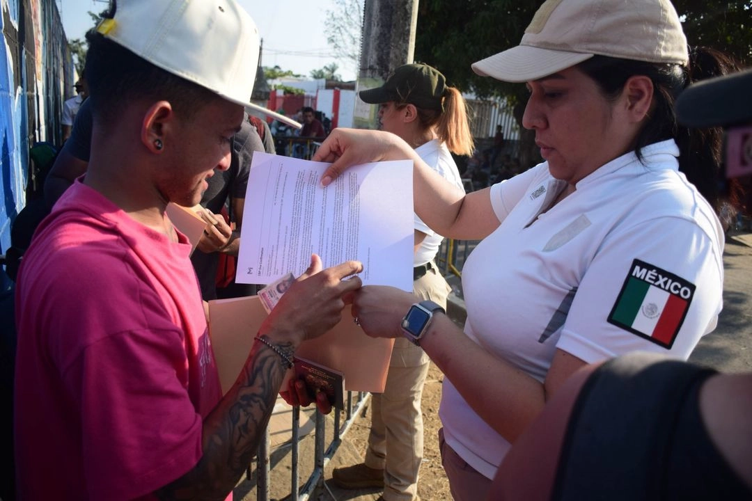 Una mujer migrante recibe información de las autoridades para regularizar su estancia en el país. 