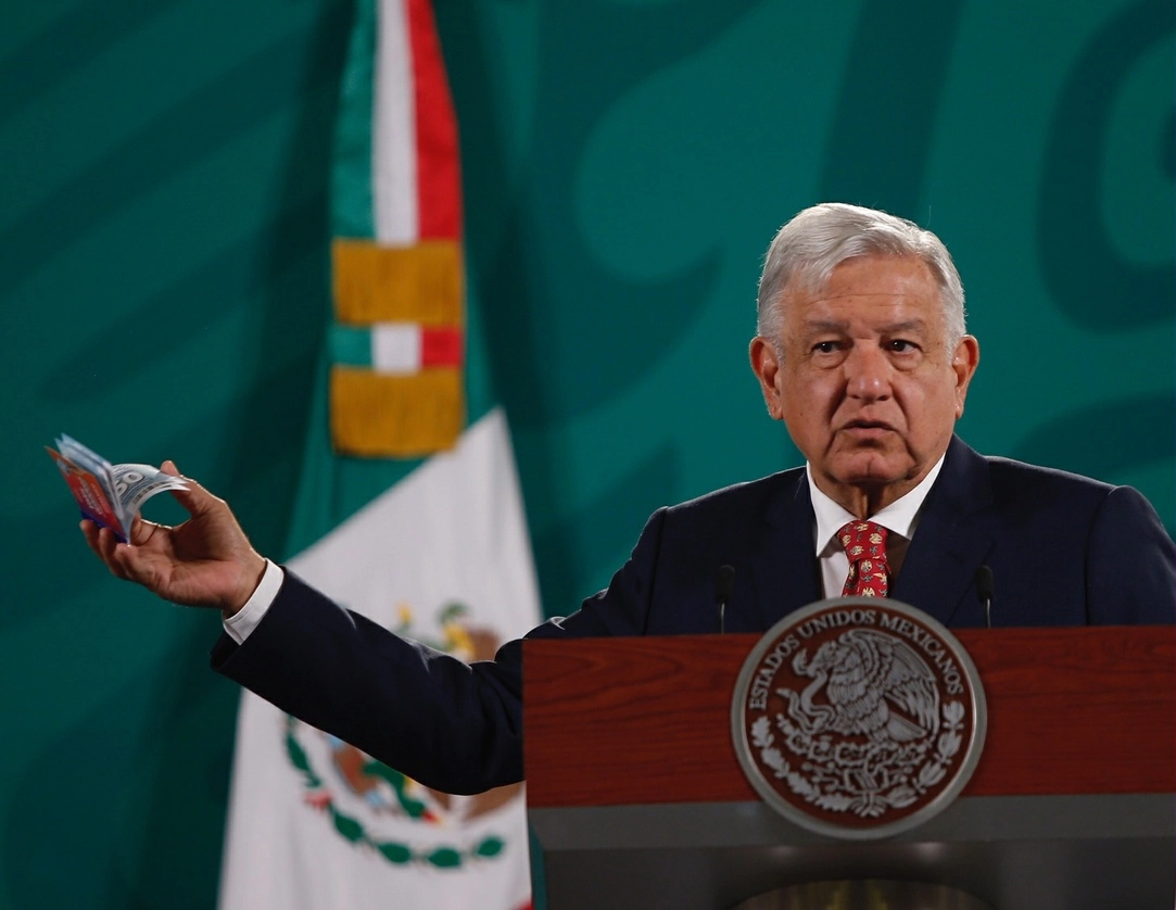 El presidente Andrés Manuel López Obrador muestra una fajilla de los vales, durante la conferencia de prensa matutina del 14 de mayo de 2021. Foto Guillermo Sologuren
