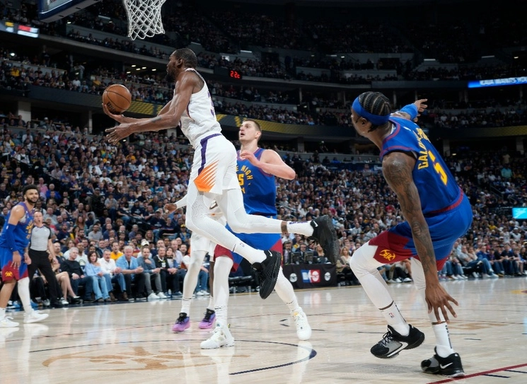 El alero de los Phoenix Suns, Kevin Durant, al frente a la izquierda, conduce hacia la canasta mientras el centro de los Denver Nuggets, Nikola Jokic, atrás a la izquierda, y el guardia Kentavious Caldwell-Pope, a la derecha, defienden en la segunda mitad del Juego 1 de una serie de baloncesto de segunda ronda de la NBA el sábado. 29 de abril de 2023, en Denver.Foto Ap