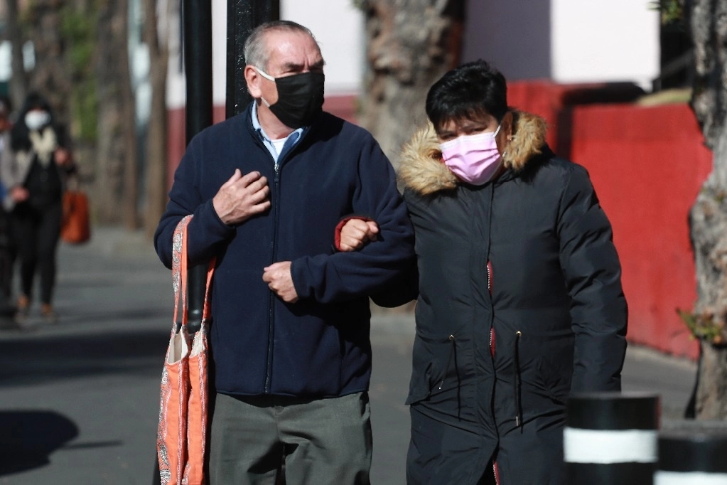 El subsecretario de Salud recordó que ademá de la pandencia la temporada de influenza inició en octubre y terminará hasta marzo o quizá abril. En la imagen, habitantes abrigados en la CDMX frente a las bajas temperaturas. Foto Luis Castillo / archivo