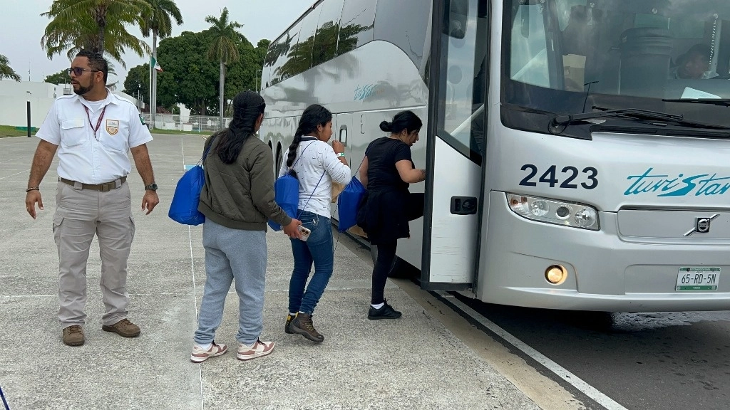 Migrantes abordan un autobús para ser trasladados a refugios y recibir atención. Foto Édgar H. Clemente