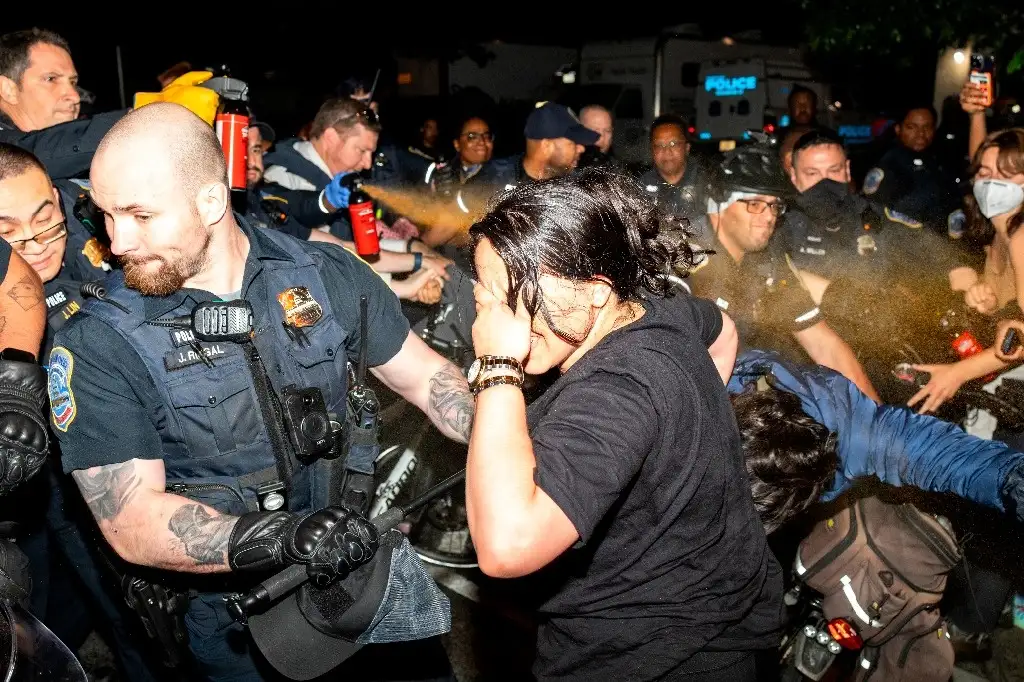Policías rocían gas pimienta a los integrantes de un campamento propalestino en la Universidad George Washington, en EU. Foto Ap