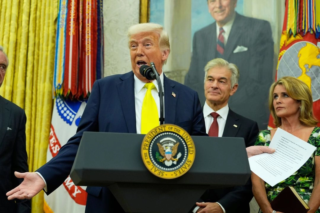 El presidente Donald Trump, de izquierda a derecha, habla mientras sostiene un documento con notas sobre Kilmar Abrego García durante la ceremonia de juramentación del Dr. Mehmet Oz como administrador de los Centros de Servicios de Medicare y Medicaid, mientras su esposa, Lisa Oz (derecha), observa desde la Oficina Oval de la Casa Blanca, el viernes 18 de abril de 2025, en Washington. Foto