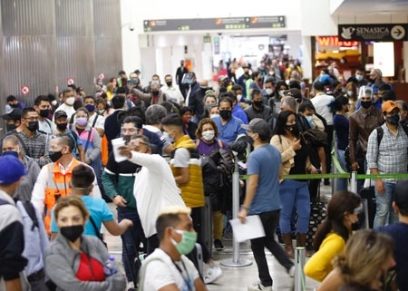 Pese al sémaforo rojo, la afluencia de viajeros aumentó significativamente ayer en el aeropuerto de la Ciudad de México, en vísperas de las vacaciones por el fin de año; aunque se les tomaba la temperatura, no guardaban la distancia recomendada para evitar contagios, además de que la mayoría de negocios, esenciales o no, estaban abiertos. Foto Guillermo Sologuren