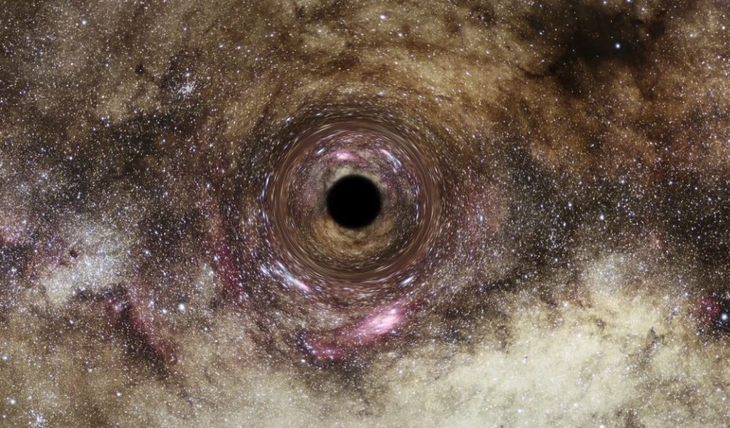Recreación artística de un agujero negro, en el que el intenso campo gravitatorio distorsiona el espacio que lo rodea. Foto Afp 
