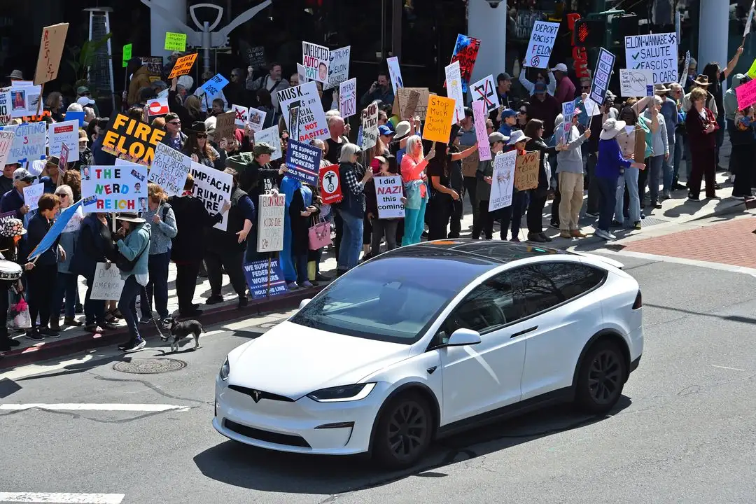 Cientos de personas protestan contra Elon Musk, el hombre más rico del mundo, para exigir su salida del Departamento de Eficiencia Gubernamental de Estados Unidos. En imagen de California, un Tesla pasa frente a los manifestantes. Foto 
