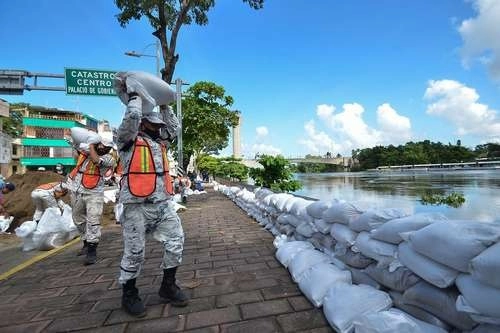 Elementos del Ejército colocaron costales con arena en el borde del malecón de Villahermosa, por donde pasa el río Grijalva. Foto Afp