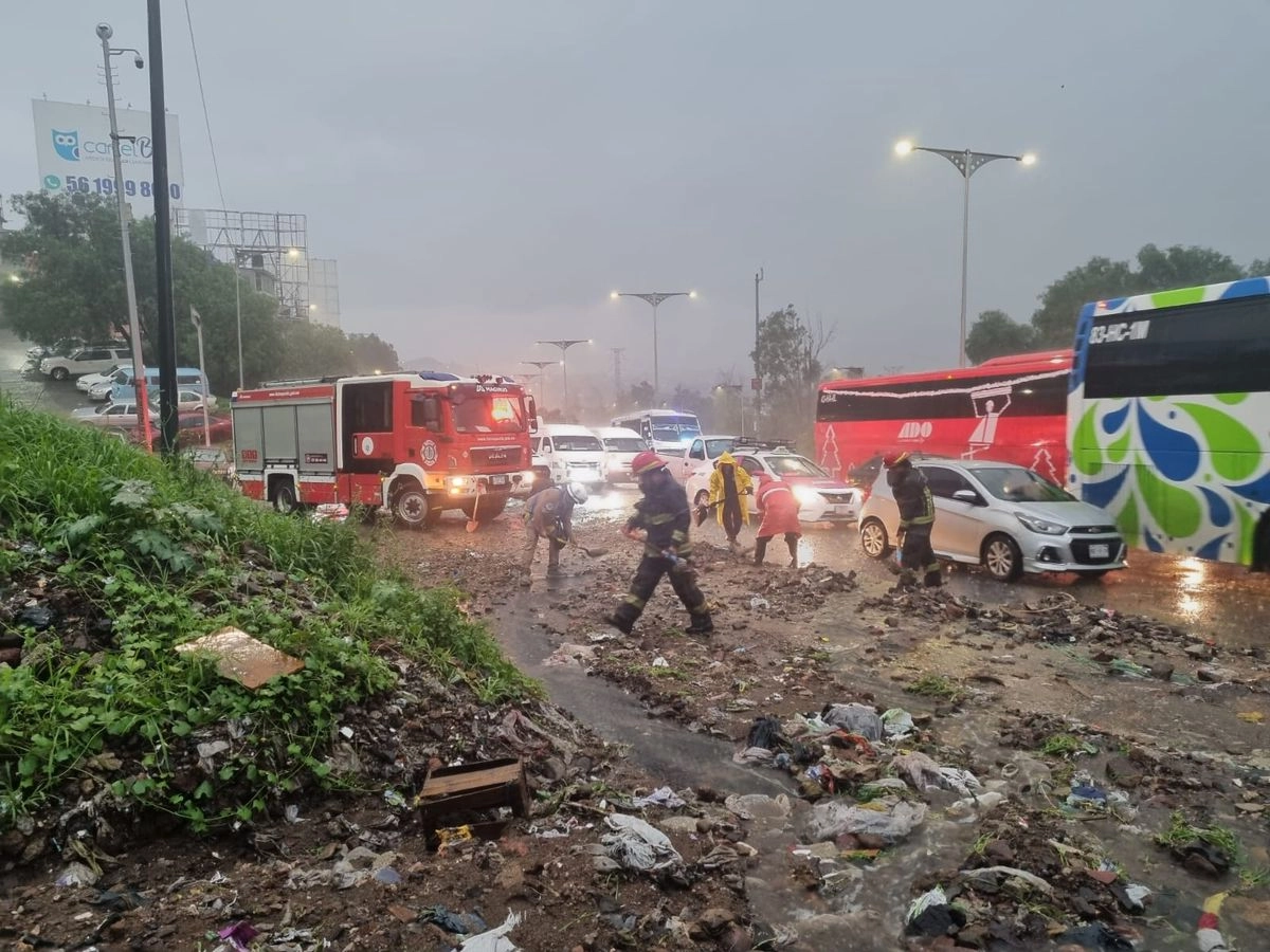 Bomberos retiran el lodo y basura que arrastró el deslave. Foto 