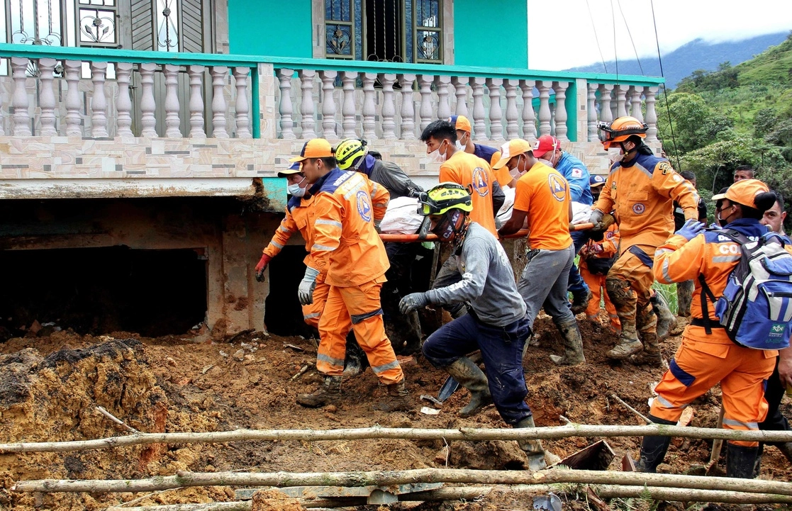 Los socorristas sacan un cuerpo del lugar donde un deslizamiento de tierra enterró dos casas en Mallama, provincia de Nariño, Colombia, el 2 de noviembre de 2021. Foto Afp