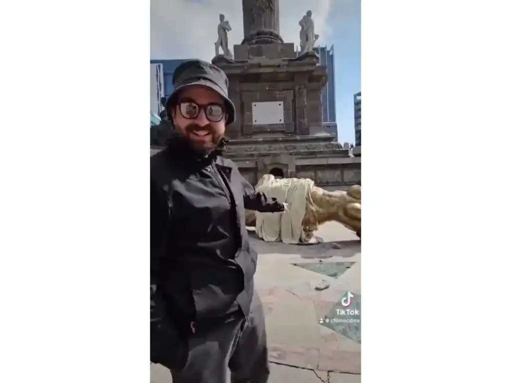 El director de cine, José Manuel Cravioto, en un video difundido por TikTok donde muestra la figura alada falsamente caída. Imagen tomada del video publicado en el perfil de la Comisión de Filmaciones de la Ciudad de México en la red social X

