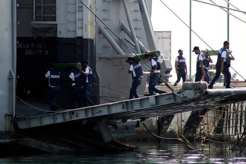 Miembros de la Secretaría de Marina Armada de México suben tanques de oxígeno, que serán donados a Cuba, a un barco en Veracruz. El cargamento también incluye suministros médicos. Foto Afp