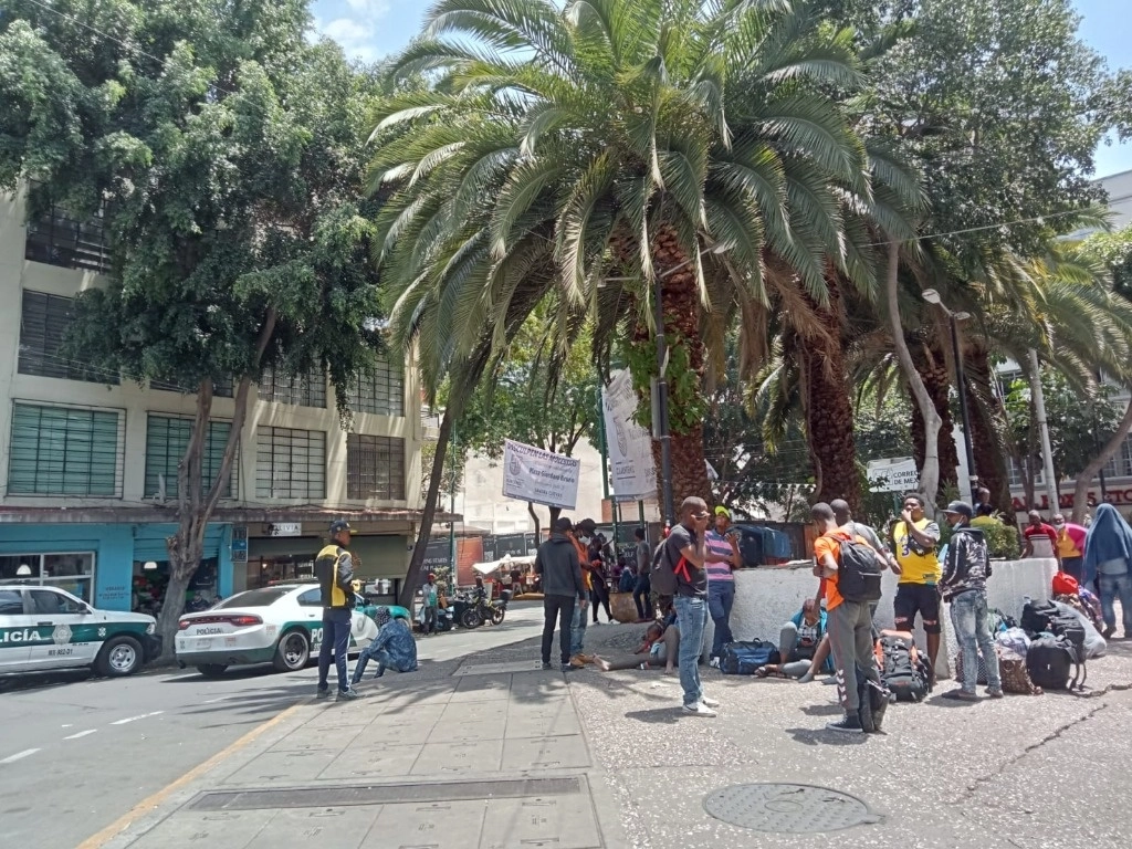 Migrantes llegaron antes del mediodía a la plaza Giordano Bruno sin saber dónde pasarían la noche, en espera de que personal de la Comar les asigne una cita. Policías del sector Ángel realizaron rondines dinámicos en la zona. Foto Elba Mónica Bravo