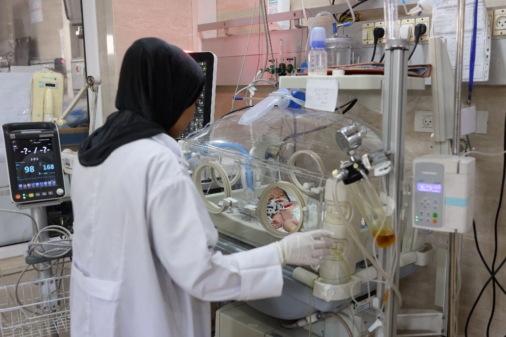 Una enfermera controla a un paciente en una incubadora en un hospital de Beit Lahia, en el norte de la Franja de Gaza, el 19 de mayo de 2024, en medio del conflicto en curso entre Israel y el grupo militante Hamás. Foto Afp