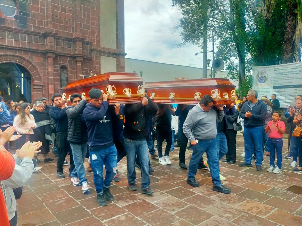 Los féretros de Alejandra Sinay Cortés Reyes y Alejandro Cortés Urbán son cargados por dolientes tras la misa que se realizó en su memoria en el templo de la Virgen de Loreto, en Tultepec, Edomex. Foto 