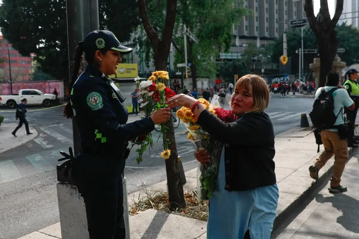 Una mujer le da una flor a una policía, minutos previos del inicio de la marcha con motivo del Día Internacional por la Eliminación de la Violencia contra las Mujeres, en la Glorieta de las Mujeres que Luchan, en la Ciudad de México, el 25 de noviembre de 2025.