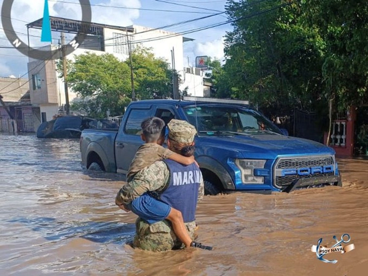 Elemento de la Marina apoya a un menor afectado por las lluvias. Foto tomada de la cuenta de X 