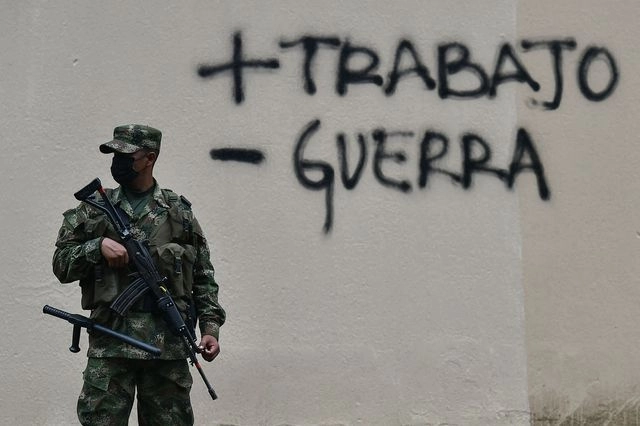 Soldado vigila las calles de Cali, Colombia, tras los disturbios registrados durante protestas contra las reformas tributarias impulsadas por el gobierno. Foto Afp
