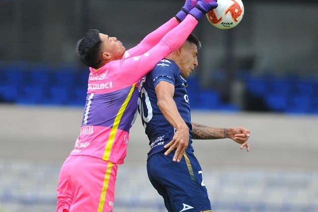 Alfredo Talavera, portero de los Pumas de la UNAM disputa por aire un balón con Mauro Quiroga, del Atlético San Luis. Foto Afp