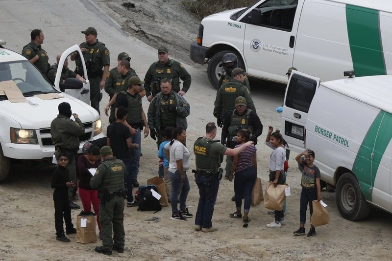 Grupo de hondureños solicitantes de asilo es detenido por la Patrulla Fronteriza tras cruzar la frontera entre EU y México, en San Diego, California el 10 de diciembre de 2018. Foto Ap