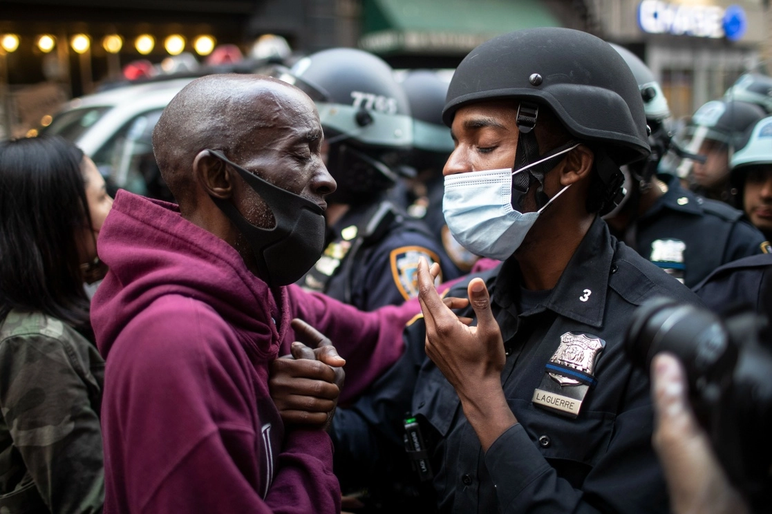 Un manifestante y policía se saludan durante la protesta. Foto Ap