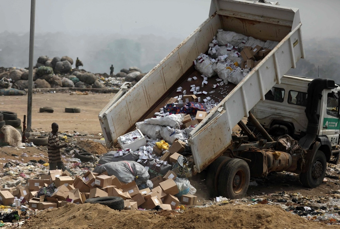 Un camión descarga un cargamento de vacunas AstraZeneca contra el Covid-19, que fueron desechadas por estar caducas, en un basurero de Abuja, Nigeria, el 22 de diciembre de 2021. Foto Afp 