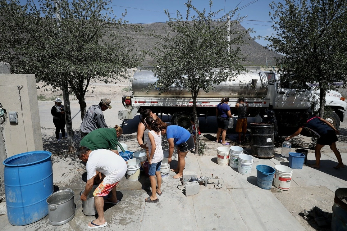 Trabajadores de la Conagua abastecen el líquido en tinacos, ollas, cubetas y garrafones a pobladores de la colonia Hacienda del Renacimiento, municipio de García, Nuevo León. Foto Antonio Ojeda 