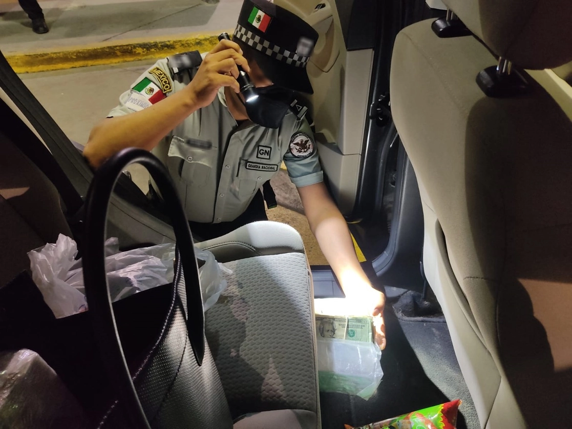 Elemento de la Guardia Nacional inspecciona el automóvil donde encontraron más de cien mil dólares sin declarar. Foto cortesía GN