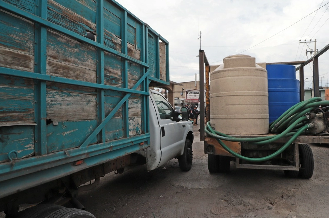Camionetas con los tinacos que fueron llenados de una toma clandestina de agua en Ecatepec. Foto La Jornada 
