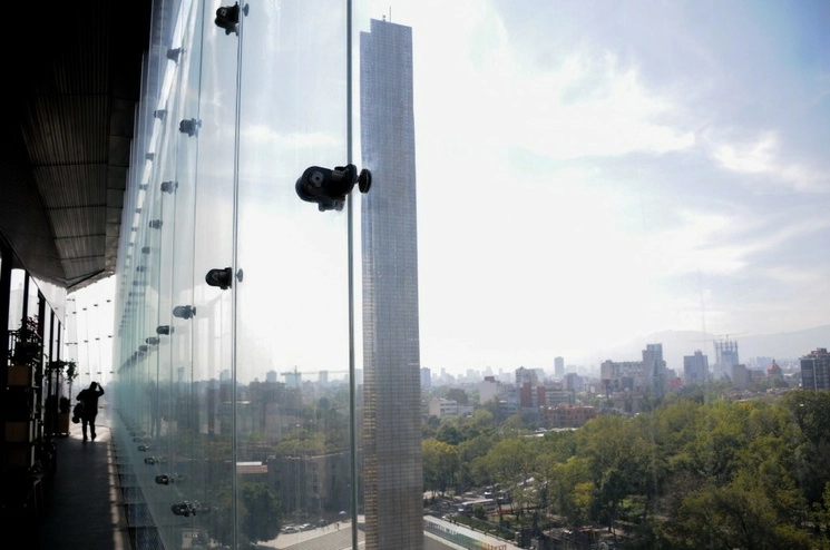 Una persona camina por los pasillos de un edificio en el Poniente de la ciudad mientras se observa la Estela de Luz sobre Paseo de la Reforma. Foto Cuartoscuro / Archivo 
