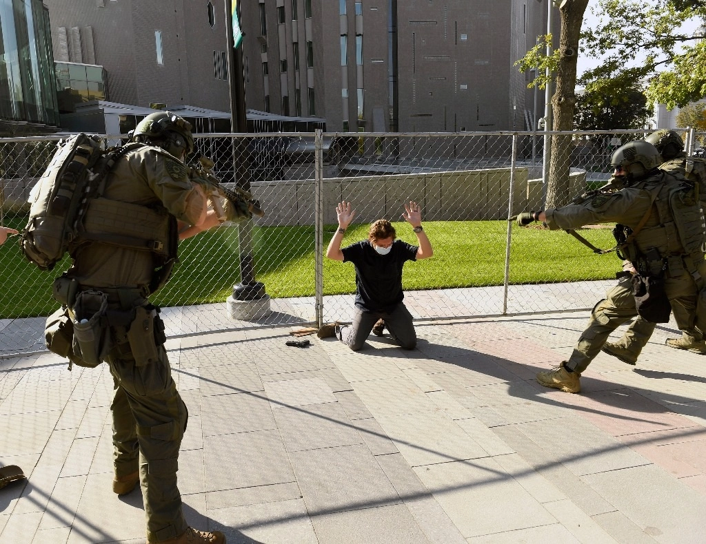 Un hombre es custodiado por policías luego de que éste disparara contra un manifestante en Denver. Foto Ap