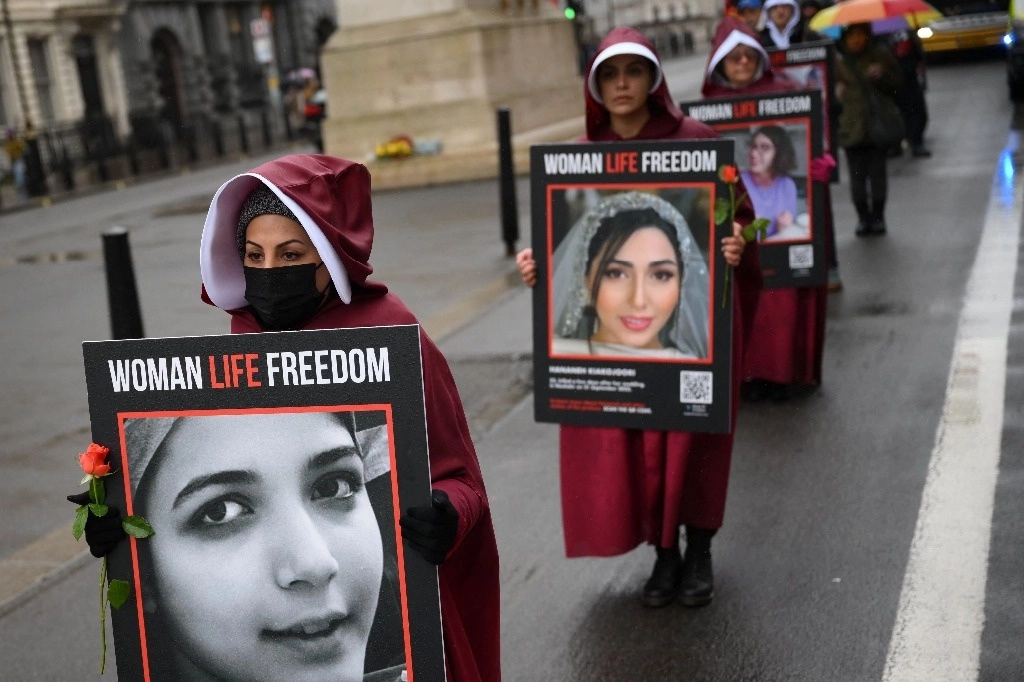 Manifestantes sostienen pancartas que dicen "Mujeres, vida, libertad" mientras se manifiestan contra la persecución de las mujeres en Irán, en la ciudad de Londres. Foto Afp