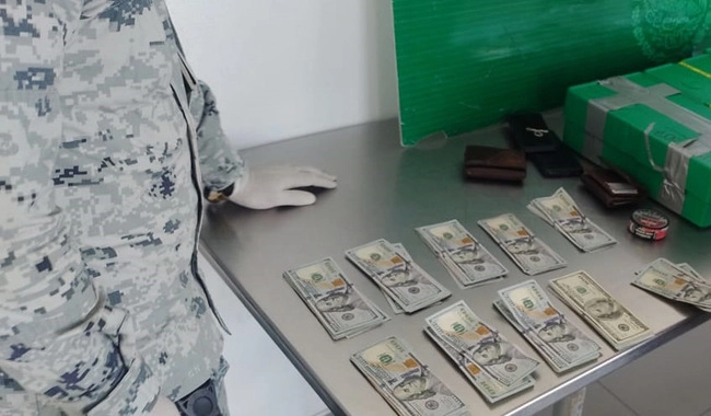 Imagen de los dólares y monedas asegurados por la Guardia Nacional y personal de Aduanas, en la Garita 1 de Mexicali. Imagen cortesía de la GN 