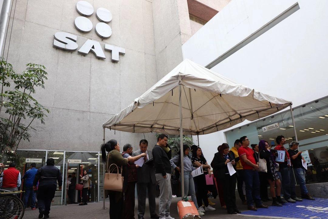 Personas esperan su turno para ingresar a realizar sus trámites en las oficinas del SAT, en la Ciudad de México. 